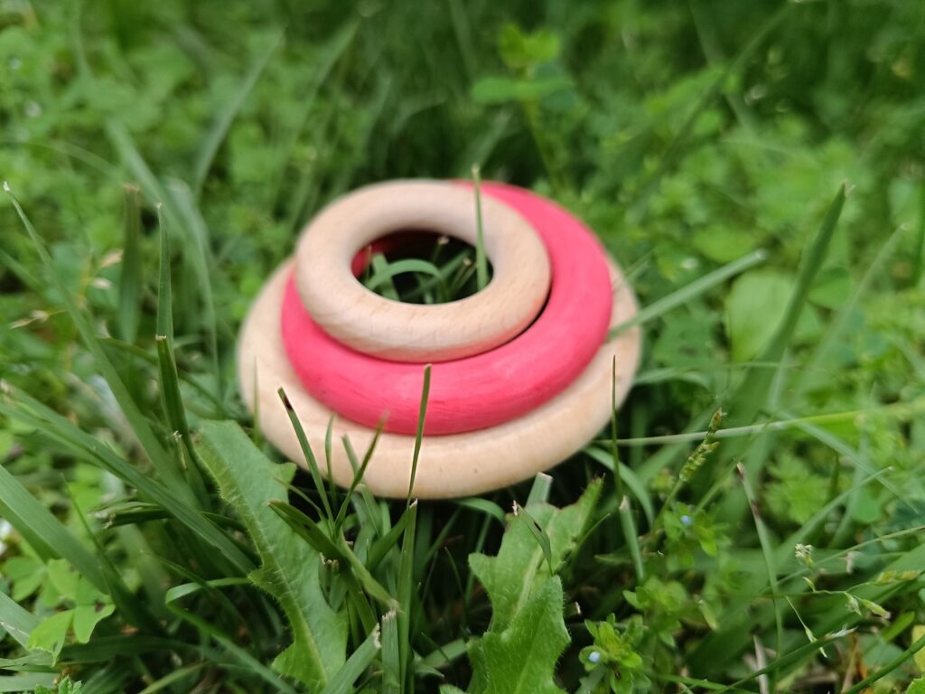 Anillas de madera sobre la hierba como material abierto inspirado en el juego libre y la naturaleza